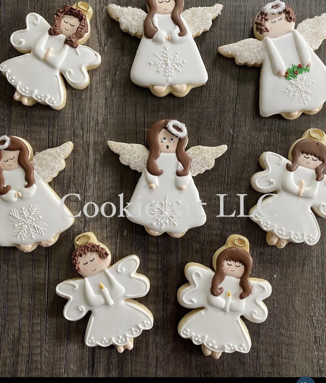 White icing angel cookies on wooden surface