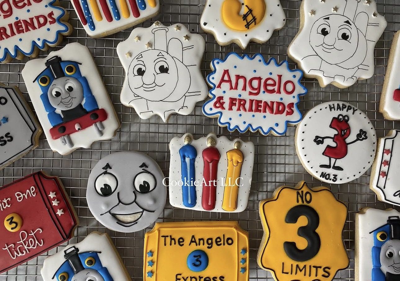 Assorted decorated train-themed birthday cookies