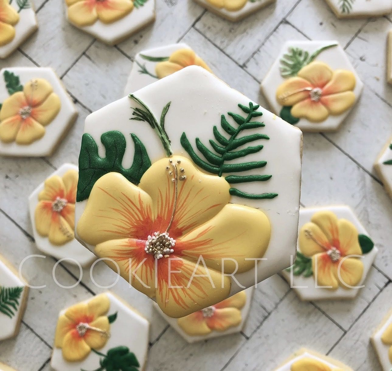 Hexagonal cookies decorated with yellow hibiscus flowers